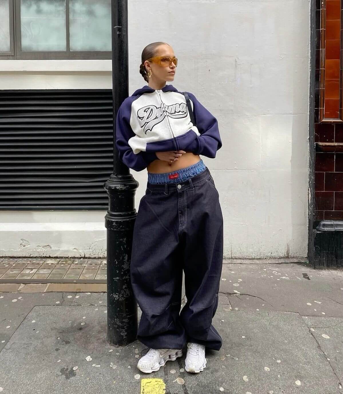 Woman in cropped navy and white hoodie with baggy jeans