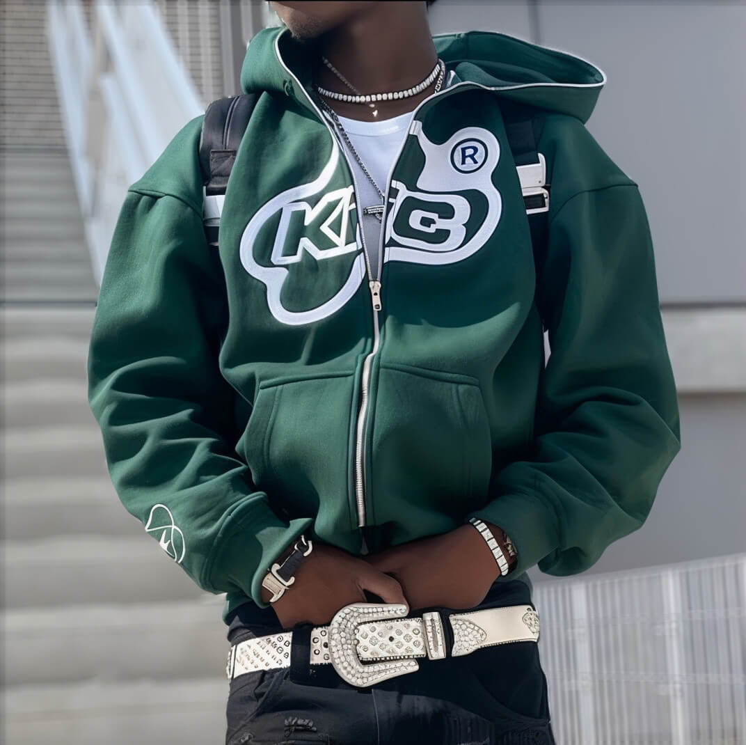 Man in green hoodie with bold logo, layered chains, and white belt, Y2K