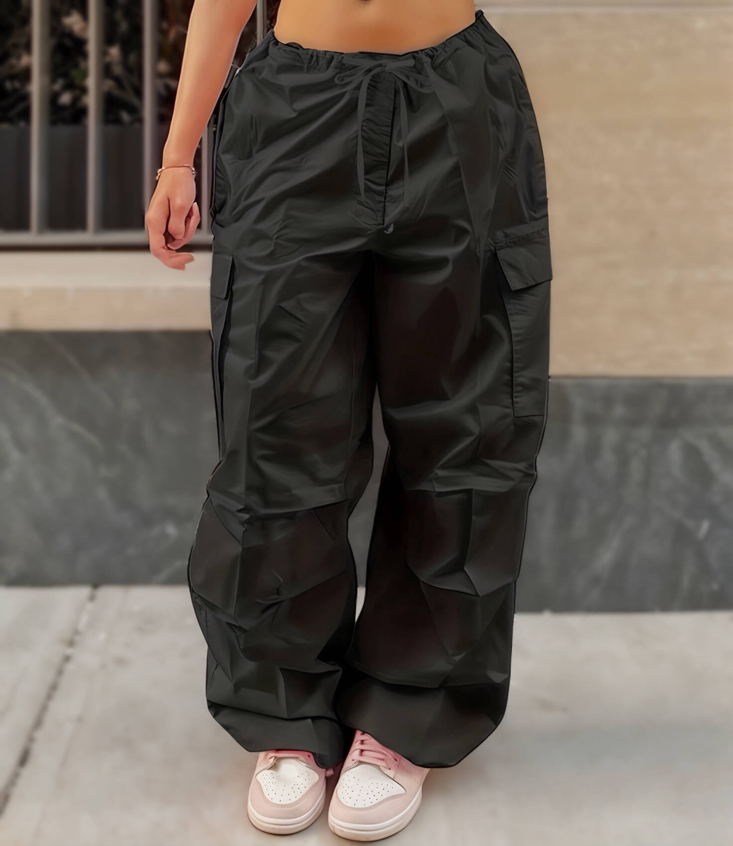 Woman in black cargo pants with drawstring waist and pink sneakers, Y2K