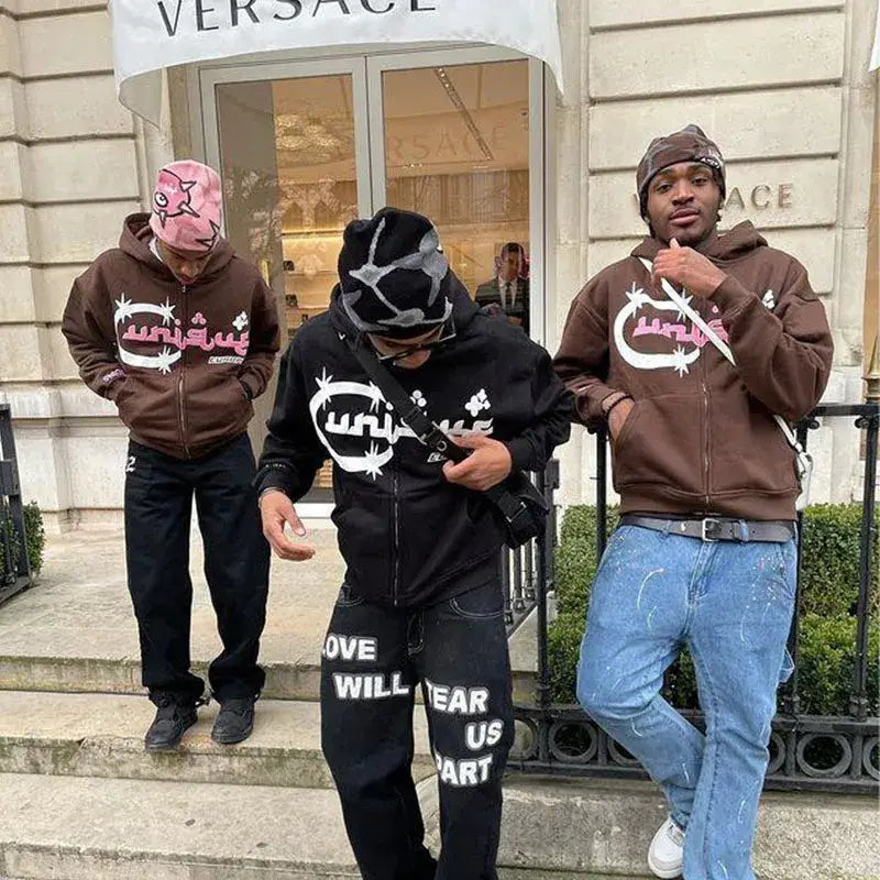 Three people in Arabic Hoodies with convenient zip-up closure outside a Versace store