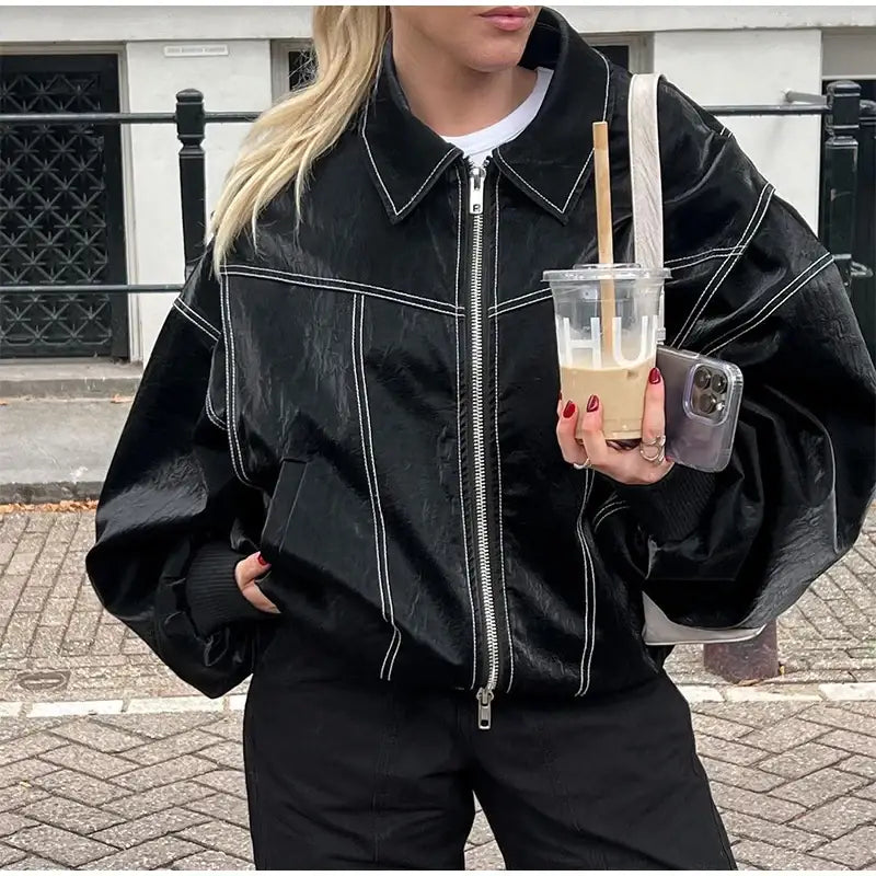 Black denim jacket featuring white contrast stitching and a front zipper