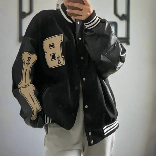 Black varsity jacket featuring beige bone patches on sleeves and chest for stylish wear