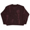 Dark burgundy cropped sweatshirt with faded graphic design on a brown knit sweater