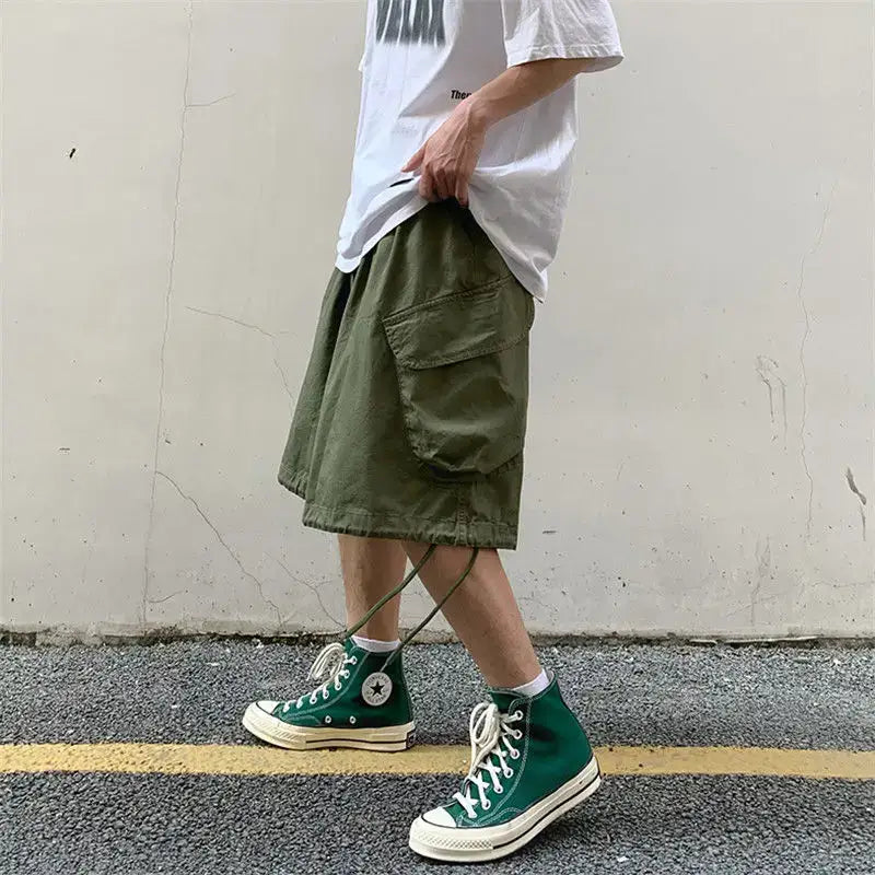 Green high-top Converse sneakers paired with olive Cargo Cargo Shorts and a white t-shirt