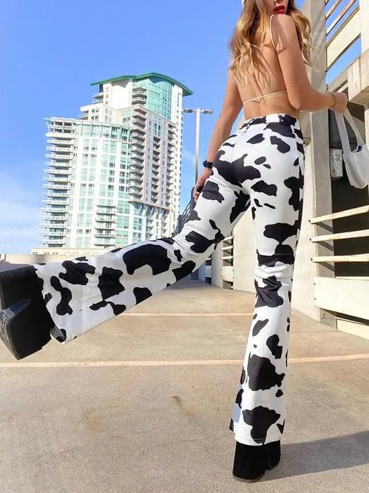 Cow print flared pants featuring a bold black and white pattern for trendy style