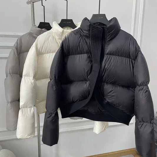 Cropped puffer jackets in neutral colors hanging on a rack for winter style