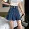 Pleated dark blue denim mini skirt with high waist and two-button closure