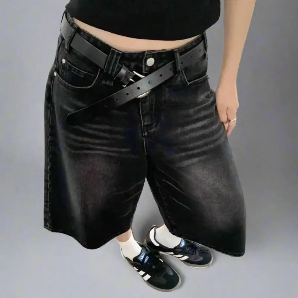 Black denim shorts with a belt paired with white socks and dark sneakers