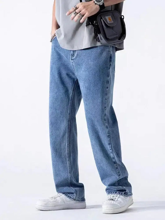 Loose-fitting dark washed denim jeans styled with white sneakers for a casual look