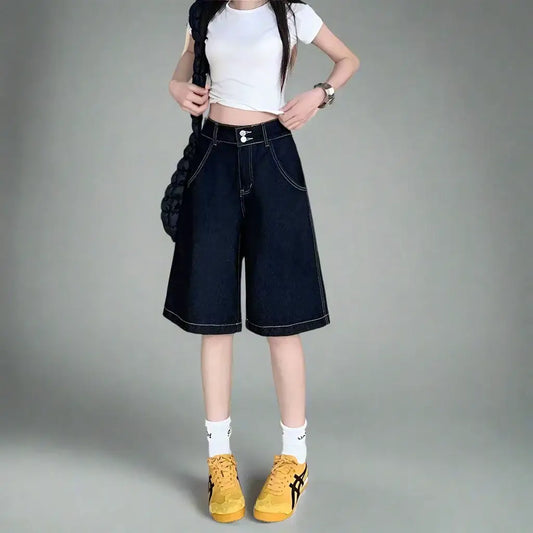 Wide-leg denim oversized shorts styled with a cropped white top and yellow sneakers