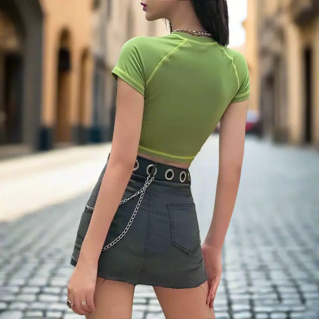 Woman in lime green fairy crop top and dark mini skirt showcasing y2k style