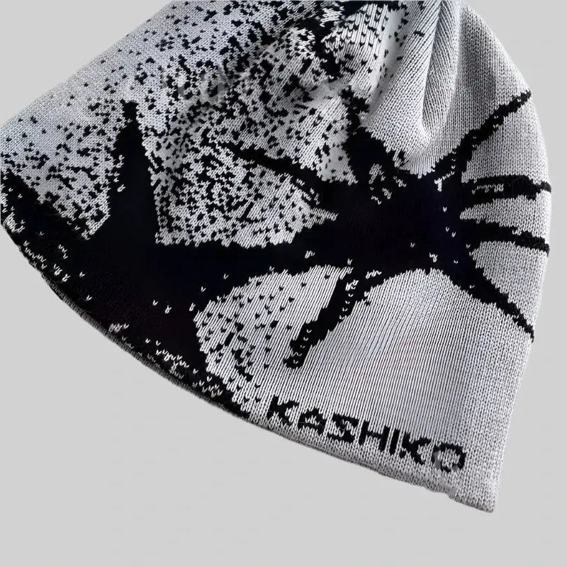 Knitted white fashion beanie with black spider design and KASHIKO text to stay warm