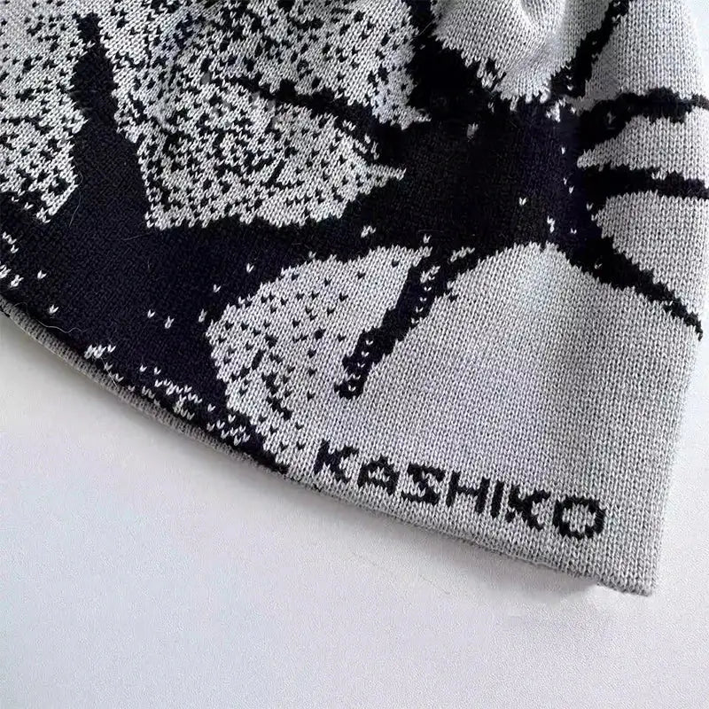 Knitted fashion beanie with spider design and KASHIKO text to stay warm in style