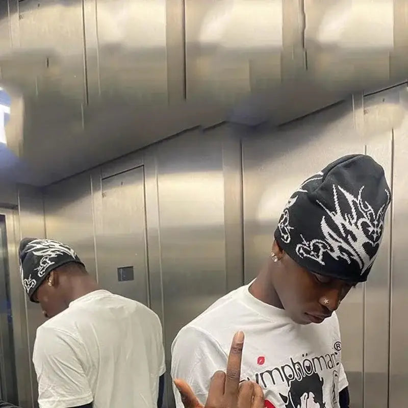 Two young men in matching Gothic Beanies in an elevator, showcasing Y2K style