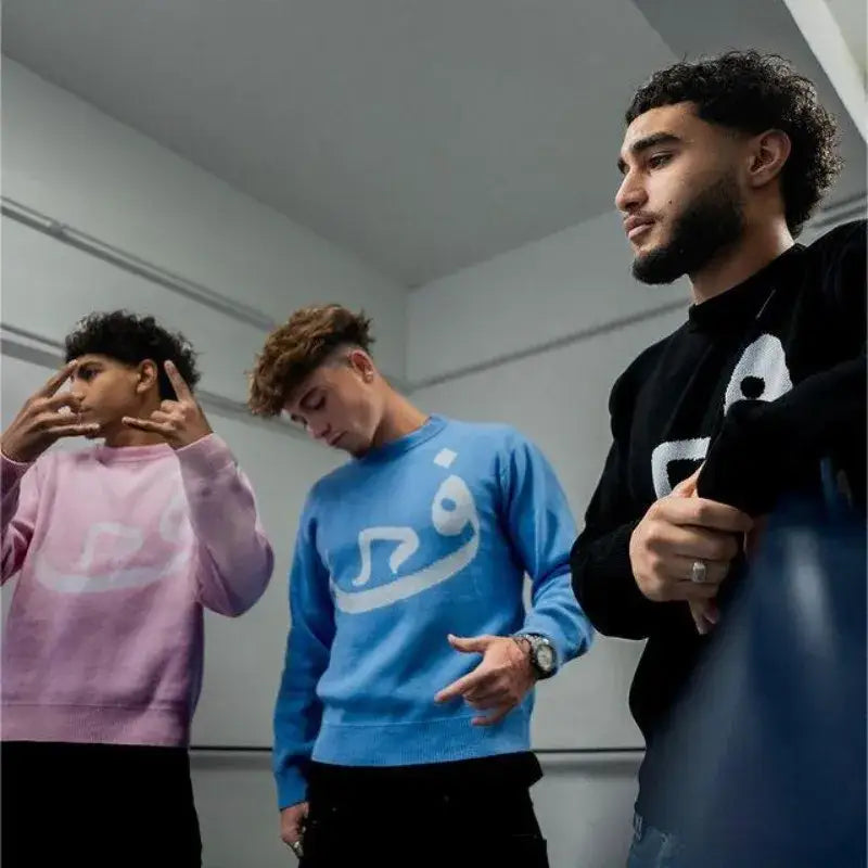 Three young men in colorful Habibi Sweaters showcasing Y2K styles and expressions