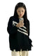 Woman in black and white trendy Harajuku sweater taking a selfie with a smartphone