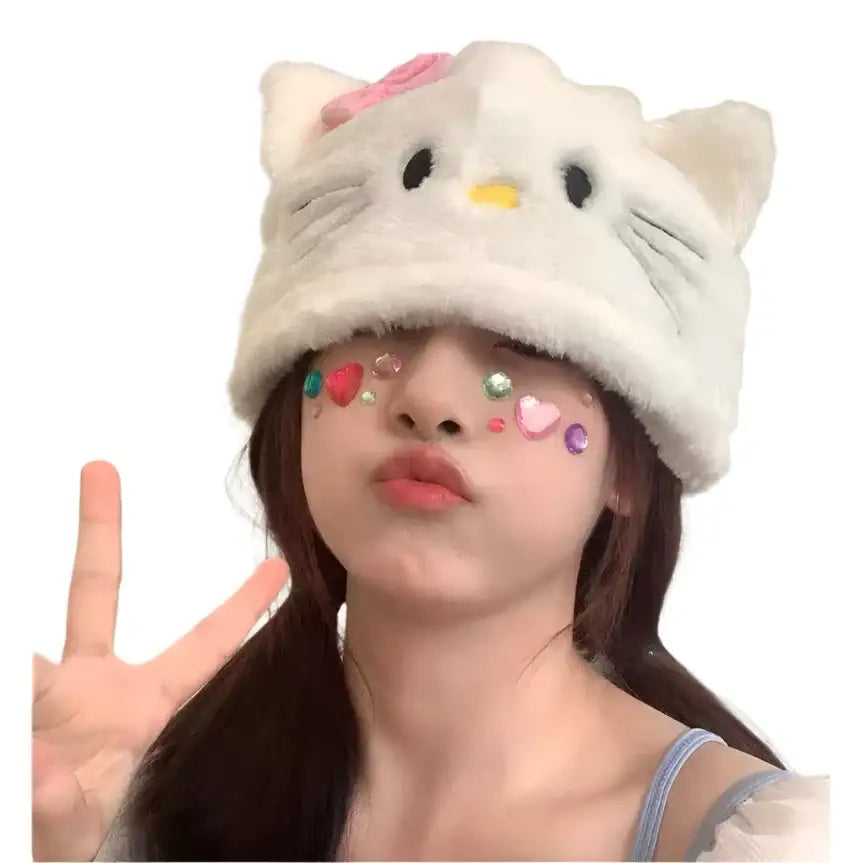 Person in a fluffy Hello Kitty Beanie with pink bow making a peace sign gesture