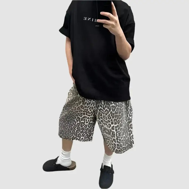 Person styled in knit leopard shorts with black t-shirt, white socks, and black shoes