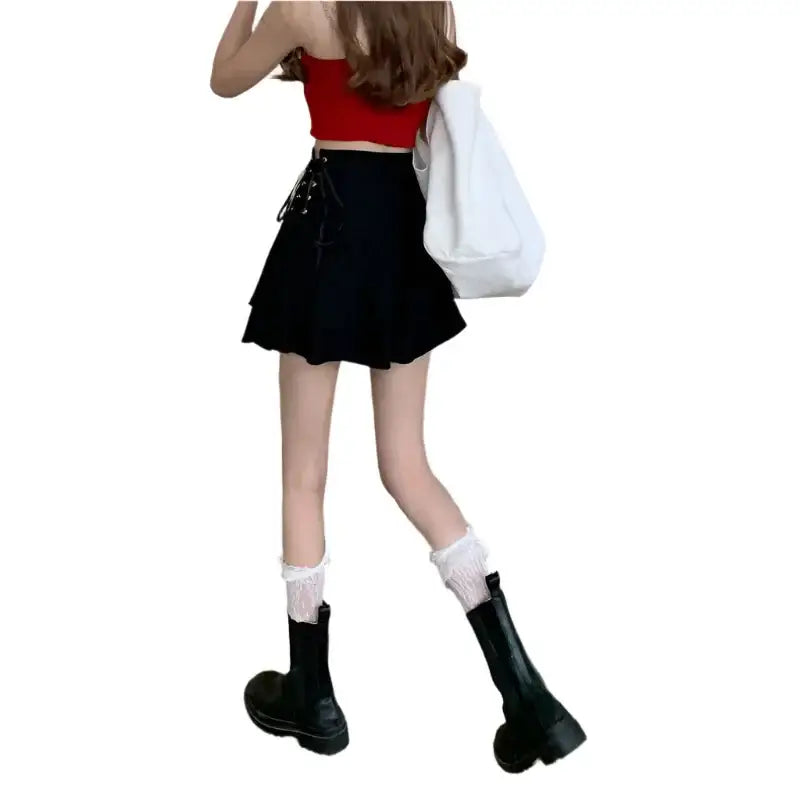 Person showcasing a Lace Up Mini Skirt with a red crop top and chunky black boots