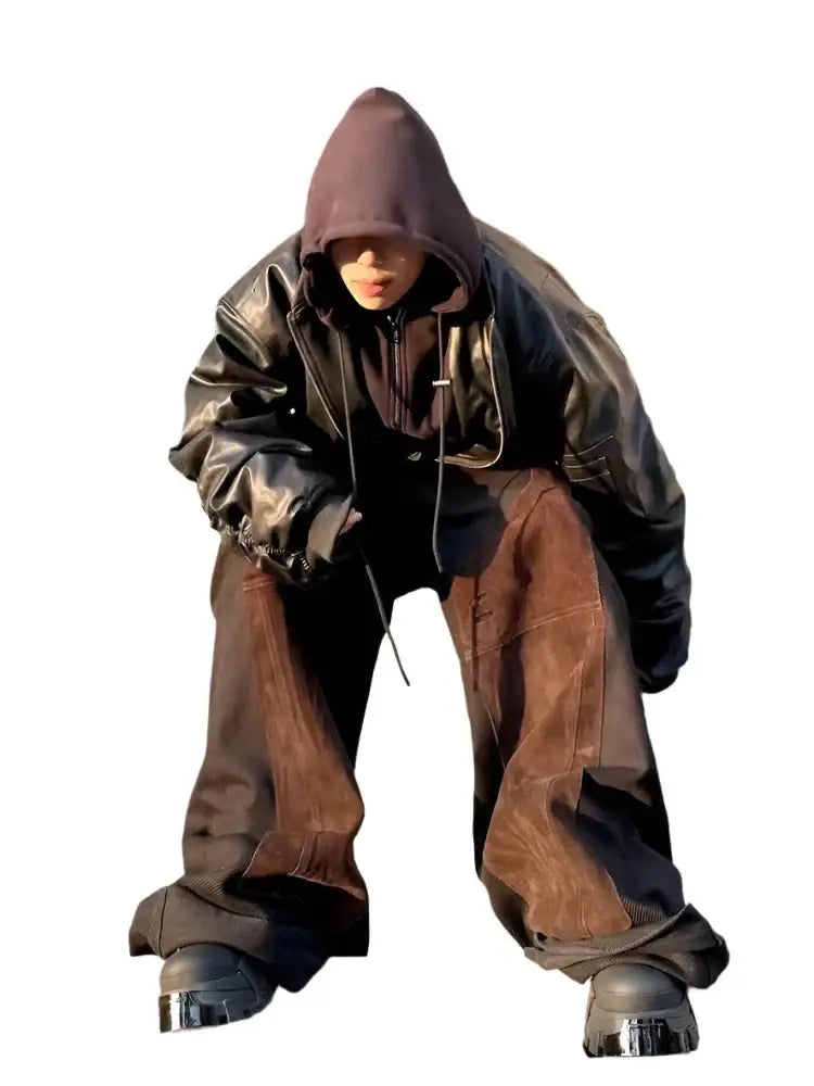 Hooded figure in baggy clothing wearing a stylish Leather Bomber Jacket crouching low