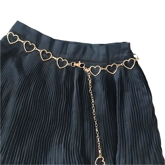 Black pleated skirt styled with a Metal Heart Belt featuring a gold chain design