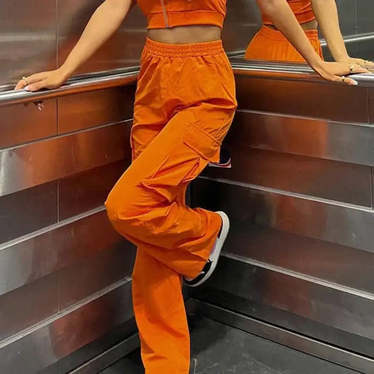 Bright orange cargo pants with matching crop top in sporty athletic outfit