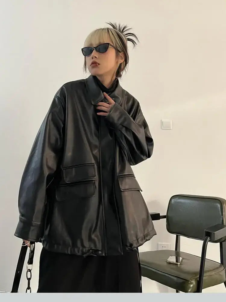 Oversized leather jacket with pockets worn by a person in sunglasses and blonde hair