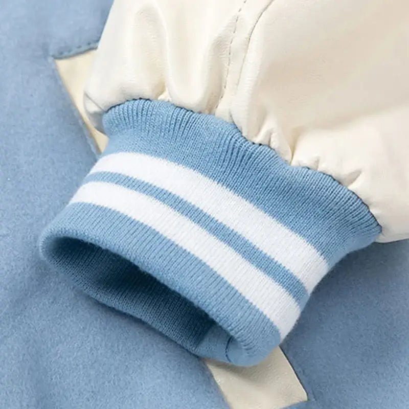 Ribbed cuff of a light blue and white striped sleeve on a Y2K Patch Jacket