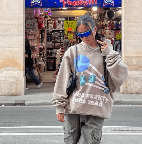 Person wearing a Y2K hoodie with a blue graphic in the Y2K Zone styled article.