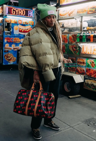 Person in a puffy beige coat and green beanie, embodying Y2K streetwear culture.