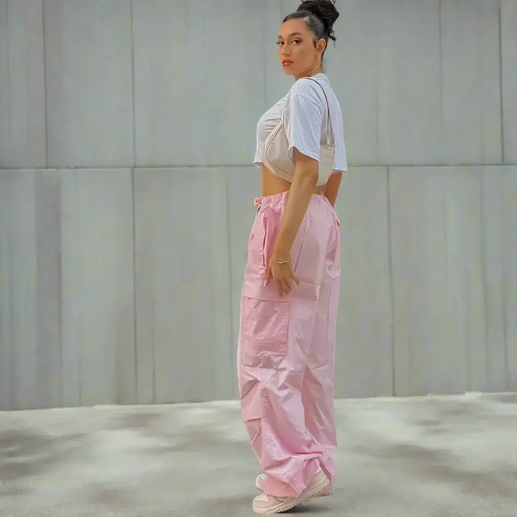 Woman in a white crop top and oversized pink cargo pants for a trendy look