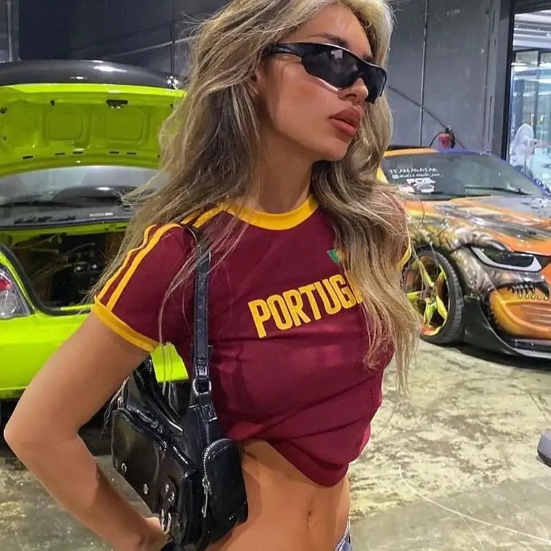 Woman in sunglasses and maroon Portugal crop top, stylish womens Y2K clothing