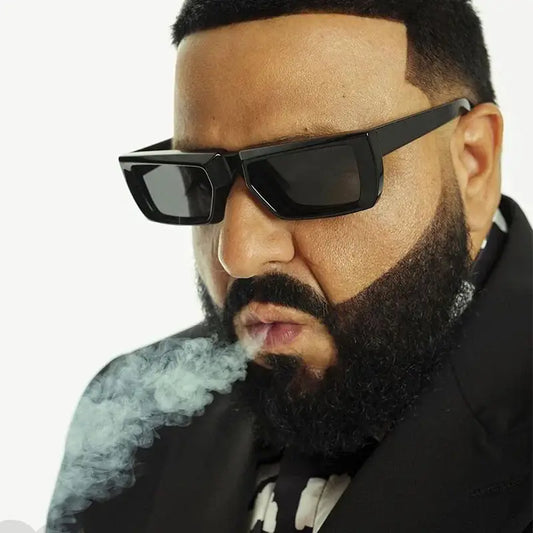 Man with a full beard wearing Punk Square Sunglasses and exhaling smoke