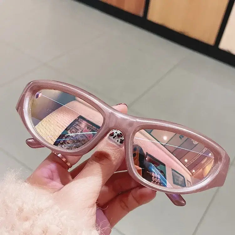 Hand holding pink-framed Punk Sunglasses with reflective resin lenses for a Y2K style