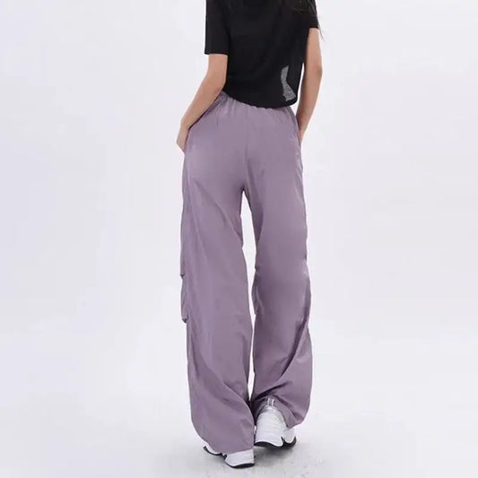 Lavender purple parachute pants styled with a black top and white sneakers