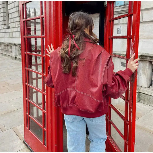 Person entering a classic Red British telephone booth in a red oversized jacket