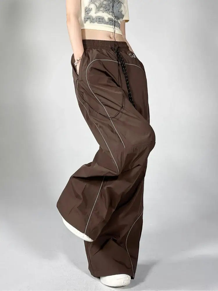 Wide-leg brown reflective parachute pants with drawstring waist and multiple pockets