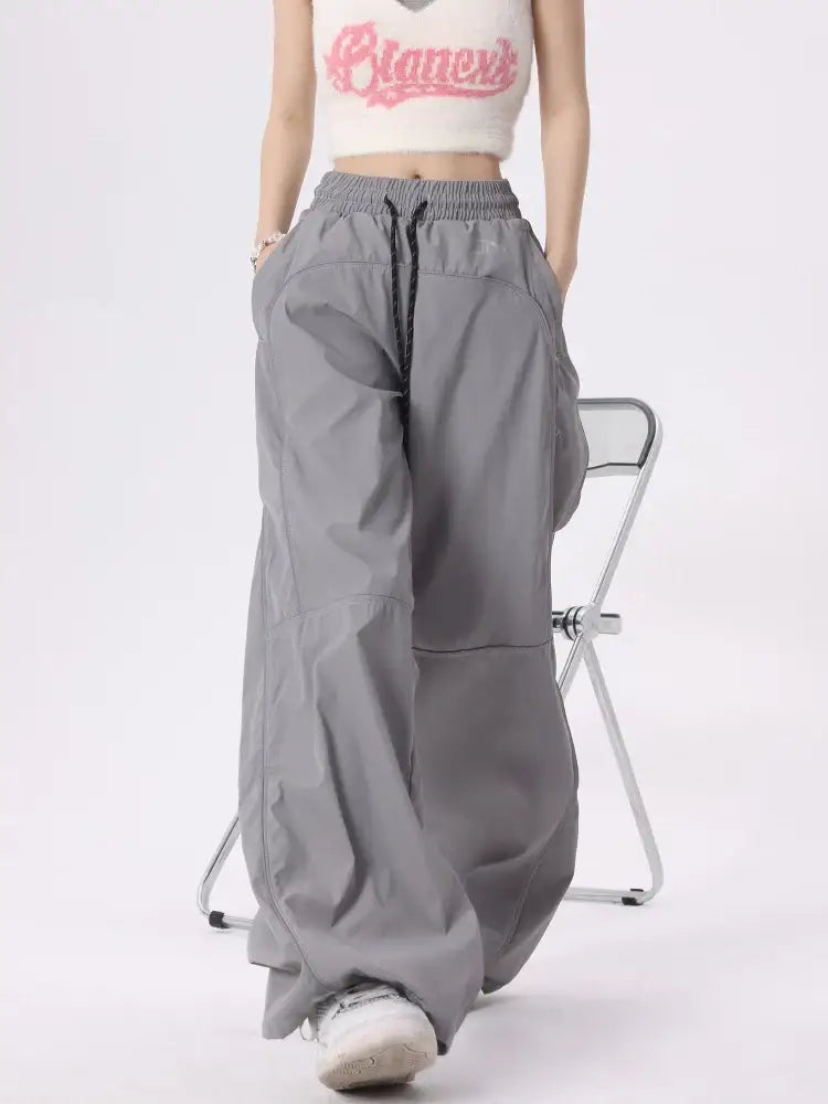 Wide-leg gray reflective parachute pants with drawstring waist and pockets