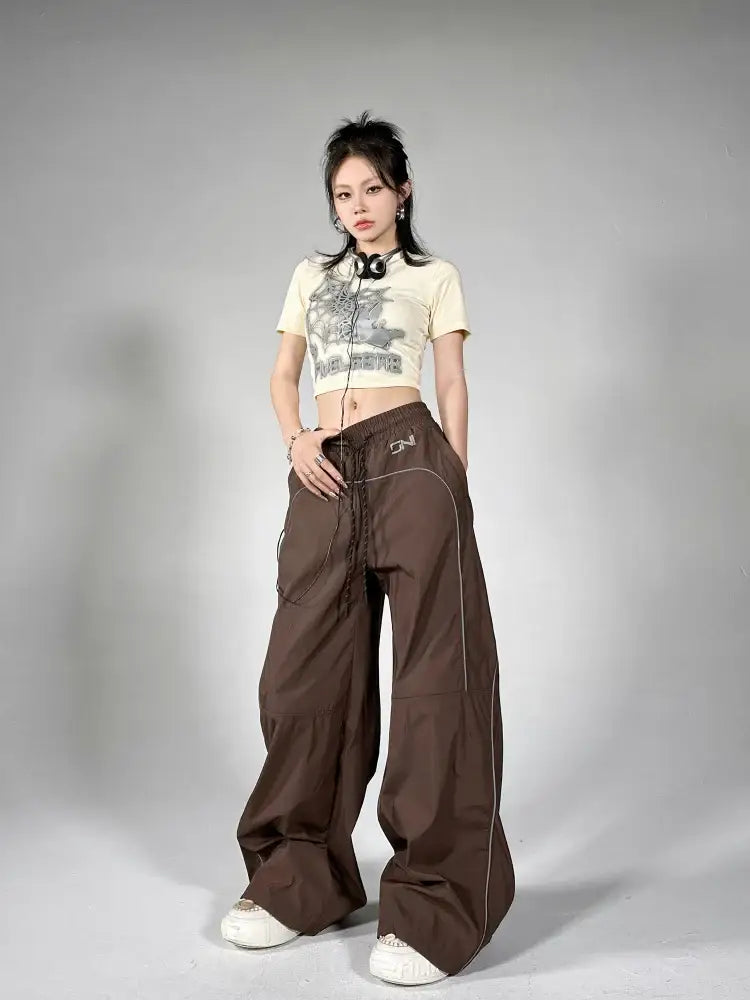 Woman showcasing eclectic style in Reflective Parachute Pants with wide-legged design