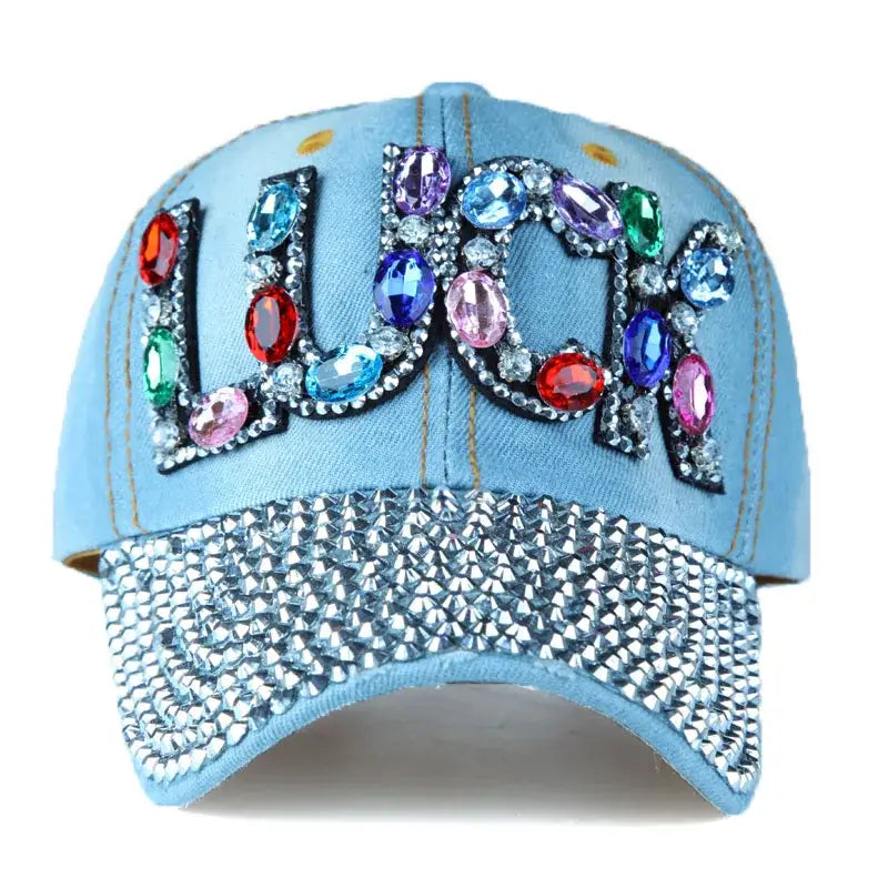 Light blue rhinestone cap with gemstones spelling LUCK and a studded brim