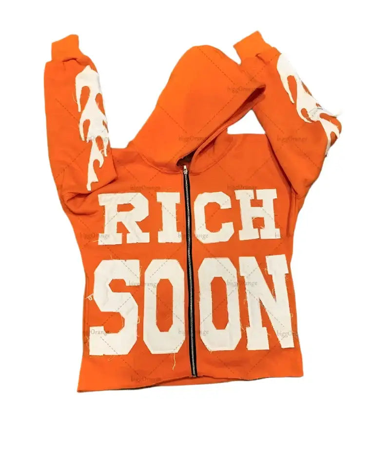 Orange Y2K hoodie with ’RICH SOON’ printed in white for a trendy look