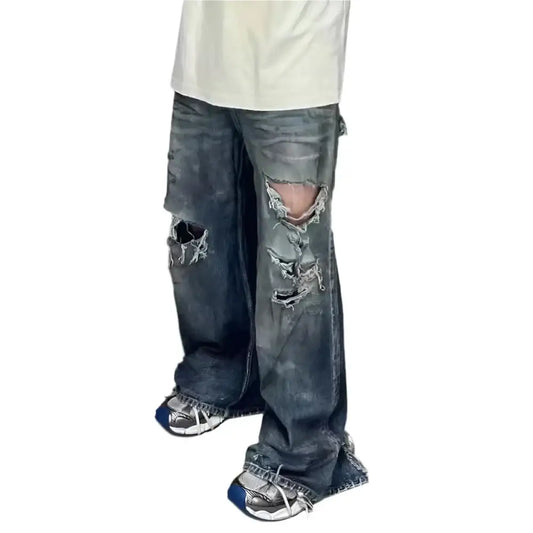 Pair of heavily distressed ripped baggy jeans with stylish rips and tears