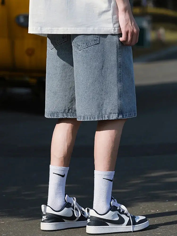 Black and white Nike sneakers with white socks styled with denim Skater Jorts