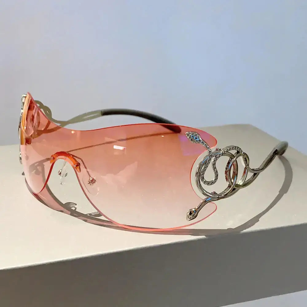 Pair of pink-tinted Y2K sunglasses with decorative silver snake-shaped arms