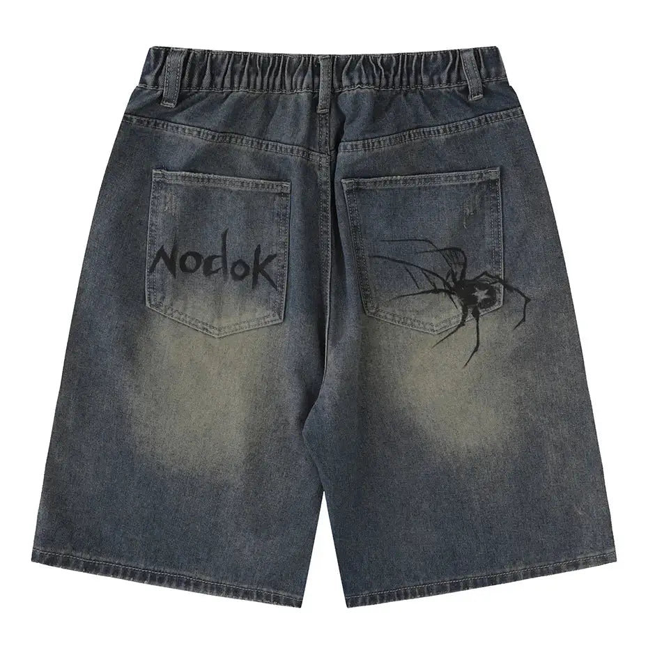 Faded denim Spider Web Shorts featuring Nodok text and spider graphic on back pockets