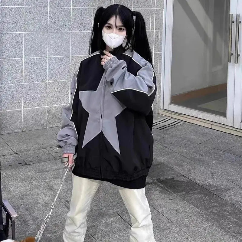 Person in a black and gray Star Jacket, white pants, and face mask showcasing Y2K style