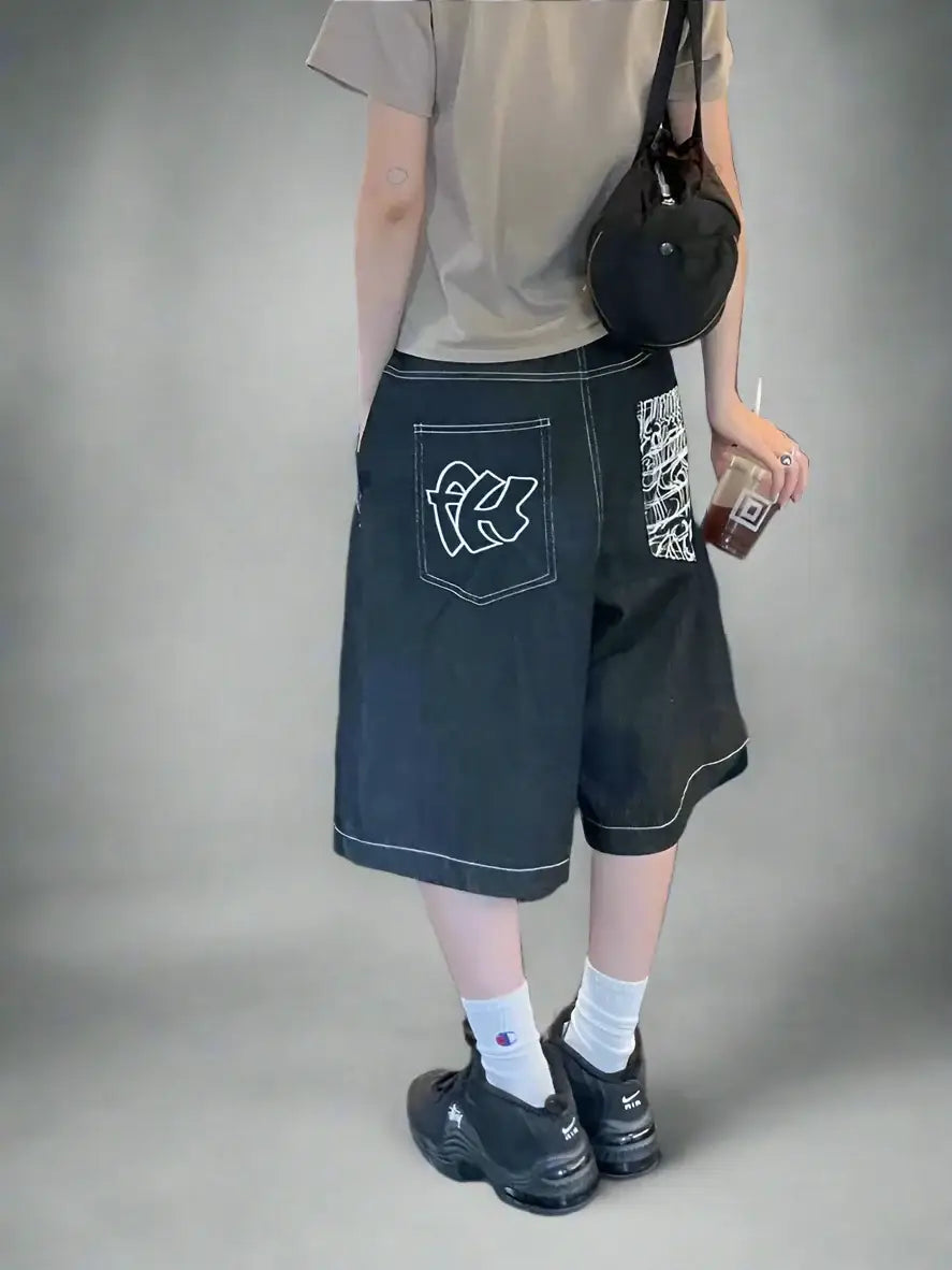 Dark baggy street style shorts featuring graffiti-style graphics on the side