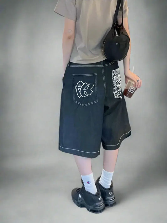 Dark baggy street style shorts featuring graffiti-style graphics on the side