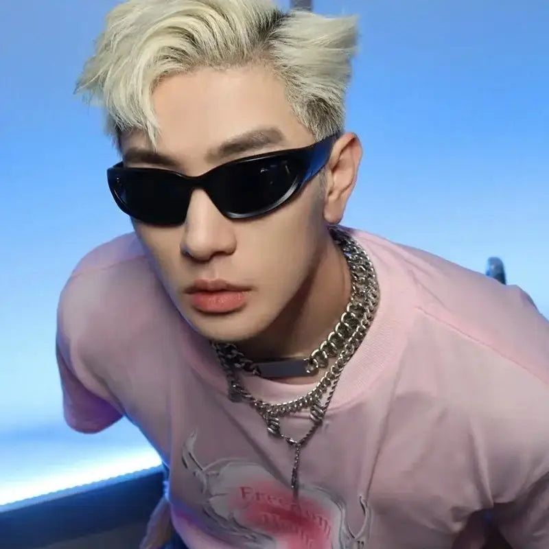 Person with bleached blonde hair in sunglasses and pink shirt showcasing streetwear sunglasses