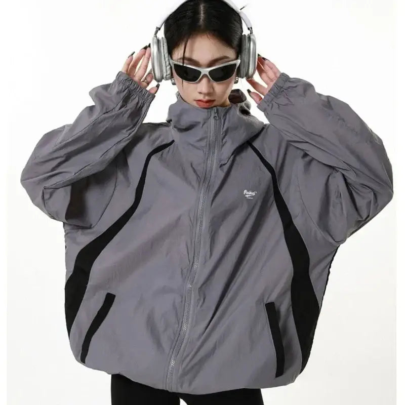 Gray oversized Techwear jacket with black accents worn by a person in Y2K style